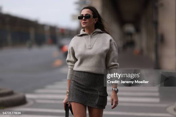 Yasemin Ögün seen wearing small black Miu Miu bag, black Balenciaga shades, black / white museforall skirt with a pocket, sand colored Isabel Marant...