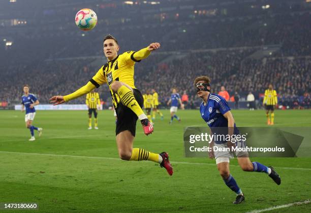 Nico Schlotterbeck of Borussia Dortmund attempts to control the ball before it goes out of play, whilst under pressure from Cedric Brunner of FC...