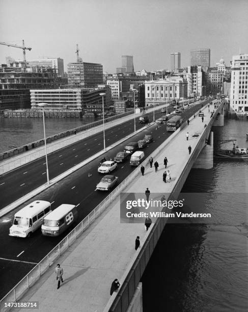 Looking towards the City of London, pedestrians and traffic cross the new London Bridge which cost 5 million pounds to build and is to be officially...