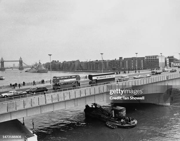 Pedestrians and traffic including a London bus cross the new London Bridge which Queen Elizabeth II has just officially opened, the old bridge has...