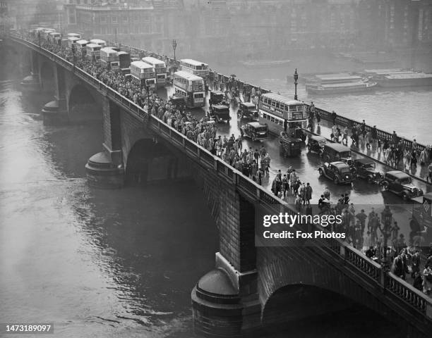 Overhead view from Adelaide House looking south of commuters and traffic including several London buses crossing London Bridge, circa 1956.