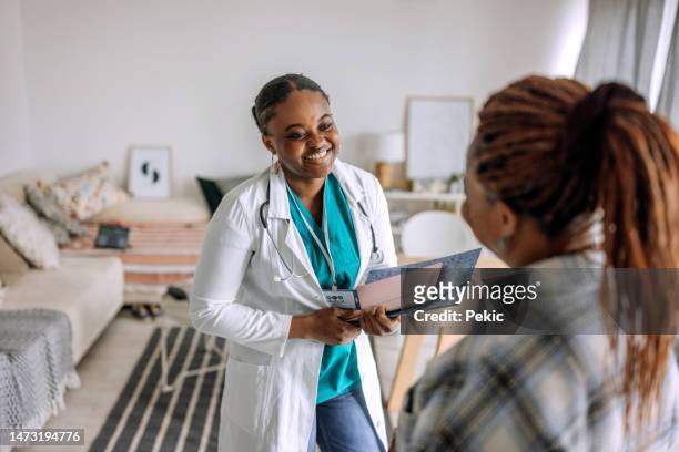 doctor and patient having a conversation in a domestic room - doctor visit stock pictures, royalty-free photos & images