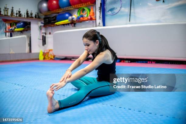 young woman stretching at gym - teens stretching in gym stock pictures, royalty-free photos & images