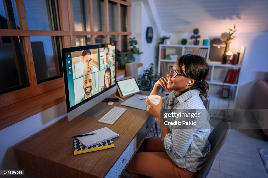 Young beautiful smiling businesswoman having video call while working from home office