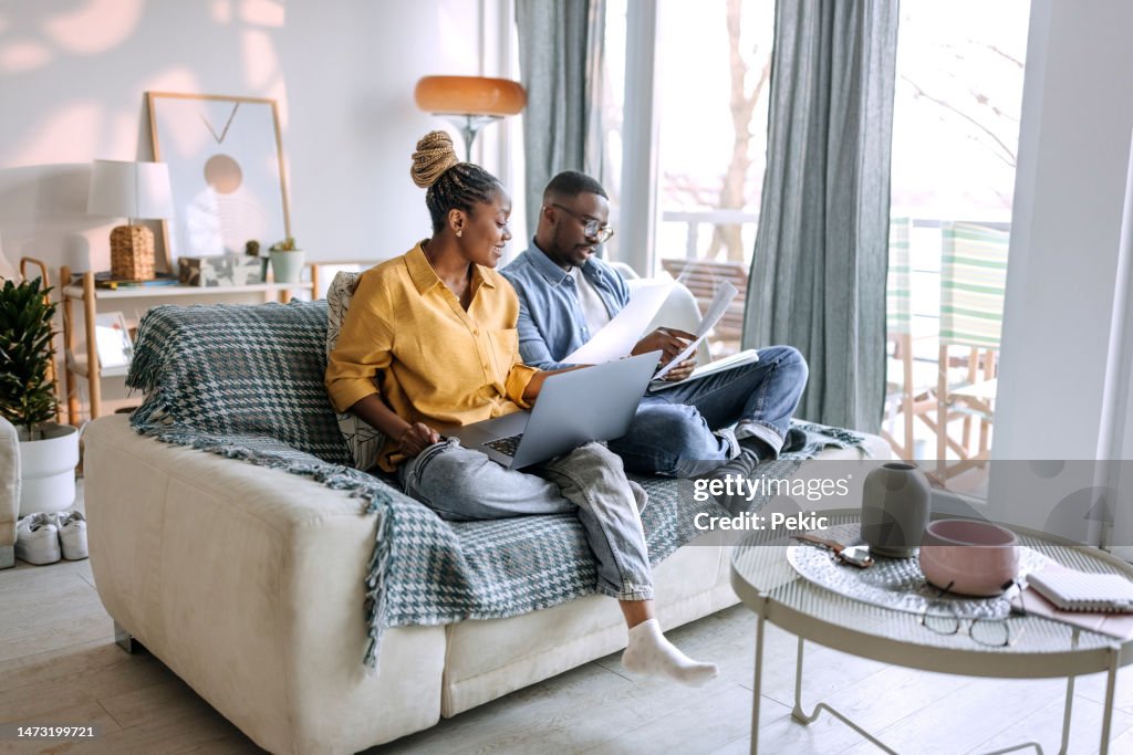 Young smiling couple working from home, going over paperwork