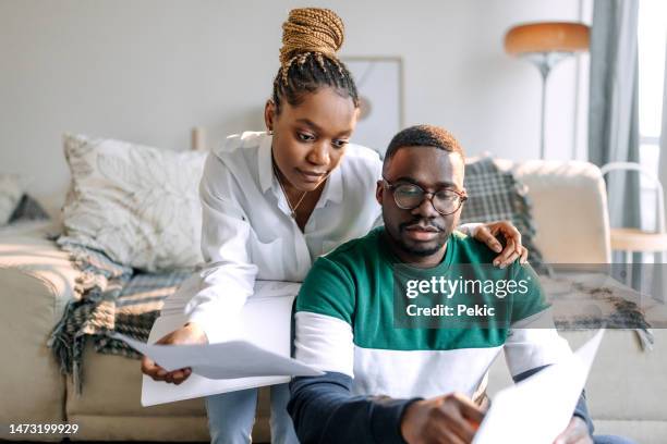 couple going over bills together at home - rate of love stock pictures, royalty-free photos & images