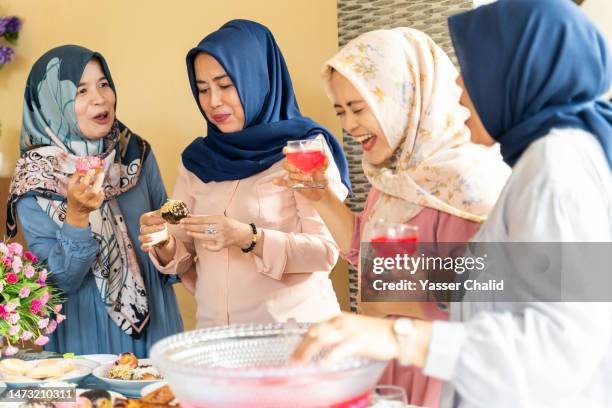 family drinking and talking at lunch party - ramadan indonesia stock pictures, royalty-free photos & images