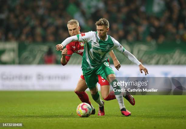 Mitchell Weiser of Werder Bremen is challenged by Mitchel Bakker of Bayer 04 Leverkusen during the Bundesliga match between SV Werder Bremen and...