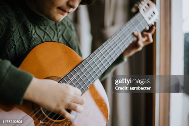 young boy playing guitar - country rock music stock pictures, royalty-free photos & images