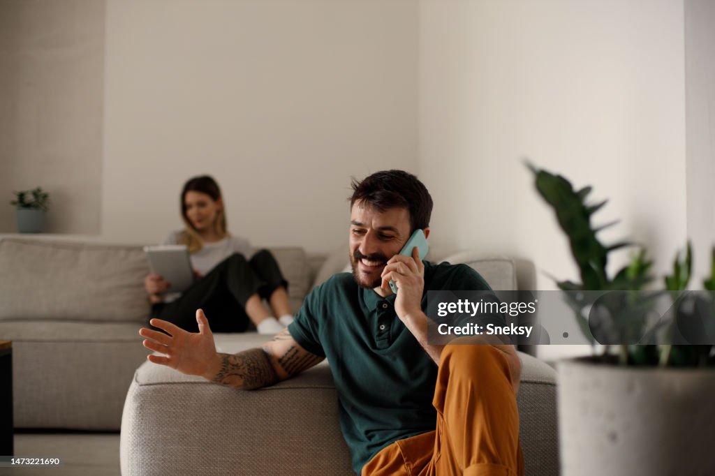 Using Phones In House Couple Using Their Phones At Home High-Res Stock Photo - Getty Images