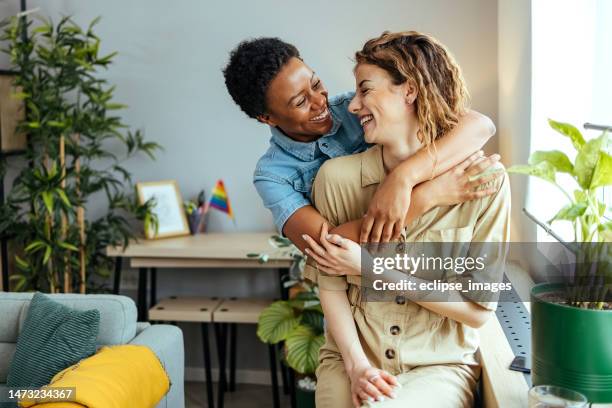 coppia che si abbraccia a casa - lesbica foto e immagini stock