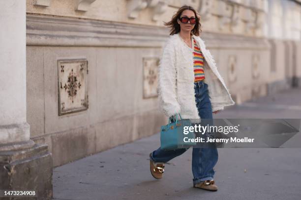 Karin Teigl seen wearing Loewe black sunglasses, Loewe dark blue logo denim pants, Mother Denim colorful striped top, Hermès baby blue leather Birkin...