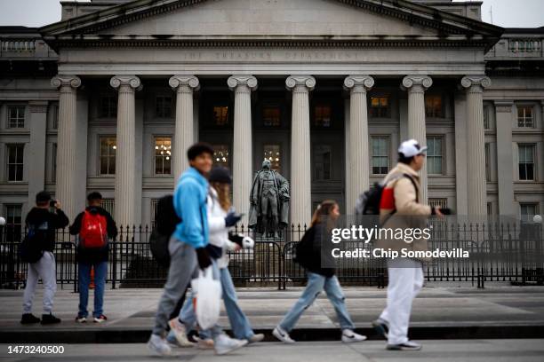 People walk past the U.S. Department of Treasury building as they joined other government financial institutions to bail out Silicon Valley Bank's...