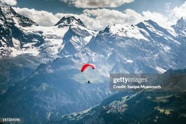 paragliding over swiss alps - paragliding stock pictures, royalty-free photos & images