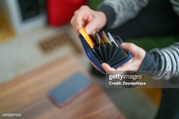 senior woman taking out her credit card from wallet - wallet stockfoto's en -beelden