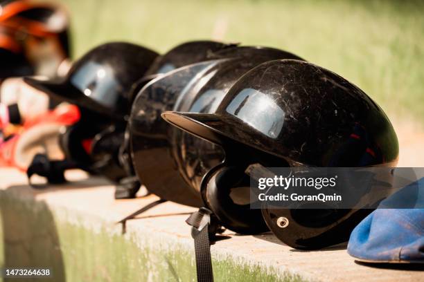 a row of baseball helmets in a dugout - casque de baseball photos et images de collection