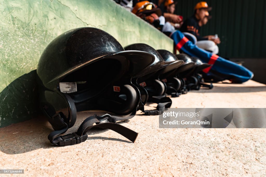 A row of baseball helmets in a dugout