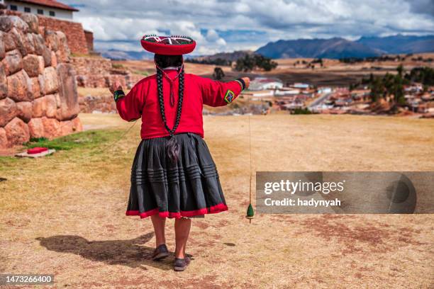 mujer peruana girando lana a mano, valle sagrado, perú - quechuas fotografías e imágenes de stock