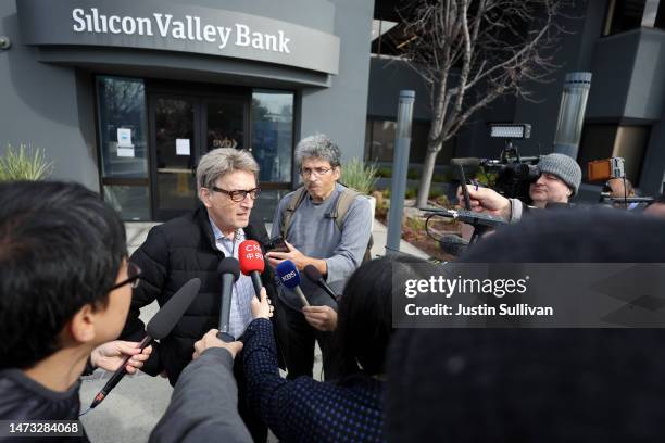 Members of the media interview a Silicon Valley Bank customer outside of the bank office on March 13, 2023 in Santa Clara, California. Days after...