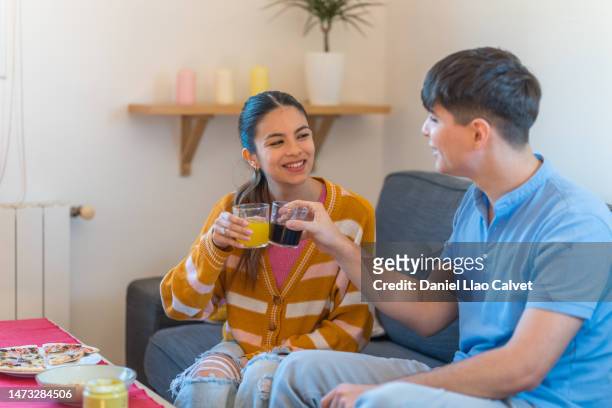 young couple toasting with refreshments in the living room - casa calvet stock pictures, royalty-free photos & images
