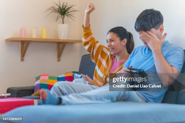 young couple at home having fun and playing video games - casa calvet stock pictures, royalty-free photos & images