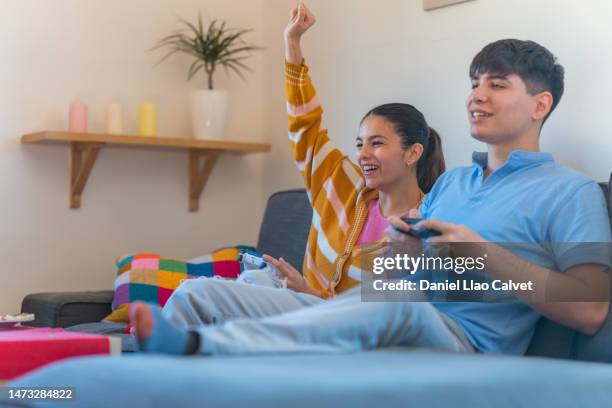 woman celebrating defeat of her boyfriend while playing video game - casa calvet stock pictures, royalty-free photos & images
