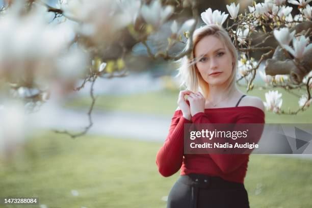 young woman in magnolia blossoms - magnolia stock-fotos und bilder
