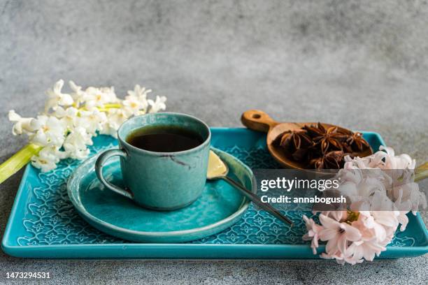 cup of black coffee with a bowl of star anise and pink and white hyacinth flowers - food styling stock pictures, royalty-free photos & images