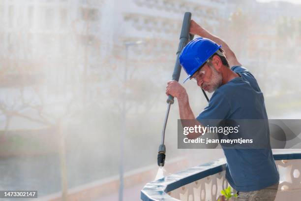 close up of worker using a high pressure water gun - splash wasser stockfoto's en -beelden
