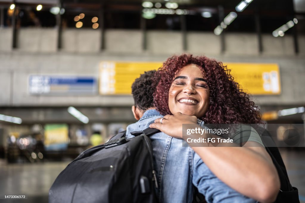 Friends embracing at the airport