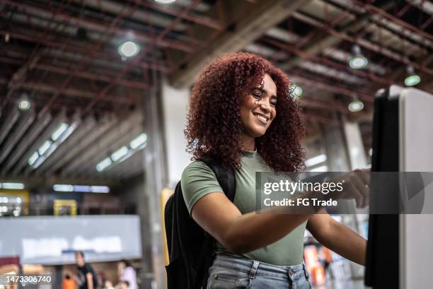 junge frau, tun, selbstbedienung, check-in, am, flughafen - selbstbedienung stock-fotos und bilder