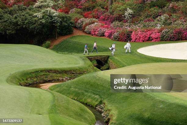 Brian Harman and Brendon Todd walk a tributary of Raes Creek on the No. 13 hole during Round 2 of the Masters at Augusta National Golf Club, Friday,...