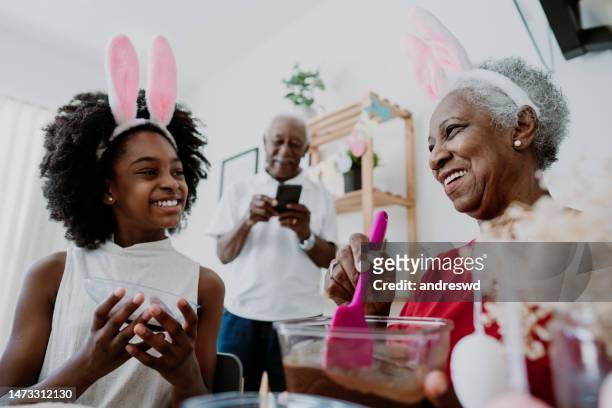 grandmother and granddaughter preparing chocolate for easter - african easter stock pictures, royalty-free photos & images