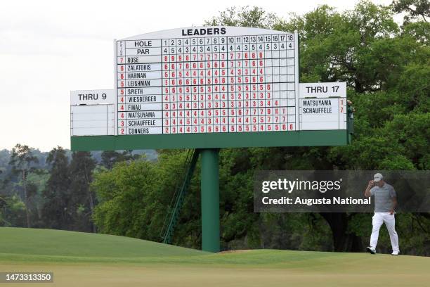 Hideki Matsuyama of Japan tips his cap under the leader board on the No. 18 green during Round 3 of the Masters at Augusta National Golf Club,...