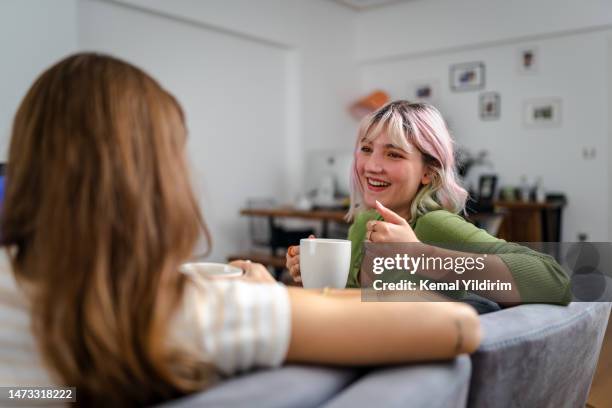 zwei junge freunde unterhalten und lachen glücklich zu hause. - freundinnen stock-fotos und bilder