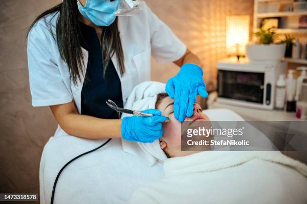beautician makes cleaning of face in spa salon - woman make up face wipes not men stock pictures, royalty-free photos & images