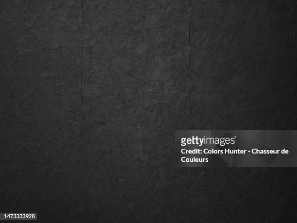 wall made of wood fiber panels, painted black, empty and clean, in brussels, belgium - black wood stockfoto's en -beelden