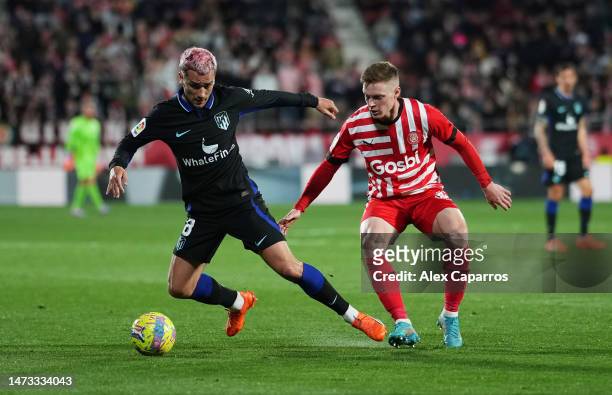 Antoine Griezmann of Atletico Madrid and Viktor Tsyhankov of Girona FC battle for the ball during the LaLiga Santander match between Girona FC and...