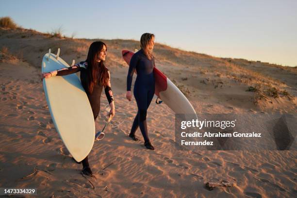 two beauty surfers walking on the beach - surfing spain stock pictures, royalty-free photos & images