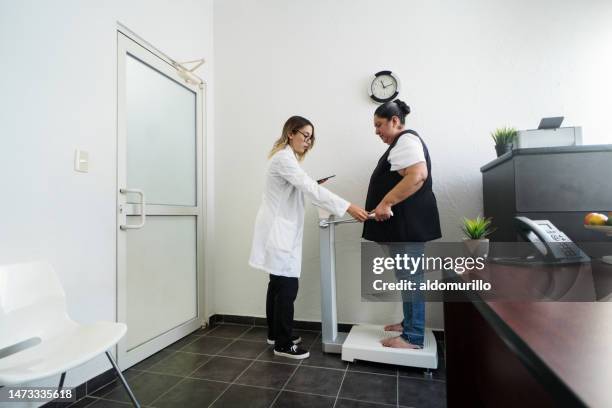 nutricionista dando mango de báscula inbody a mujer con sobrepeso - obesidad fotografías e imágenes de stock