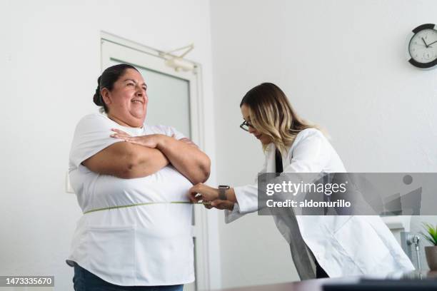 nutricionista midiendo la cintura de una mujer con sobrepeso - obesidad fotografías e imágenes de stock