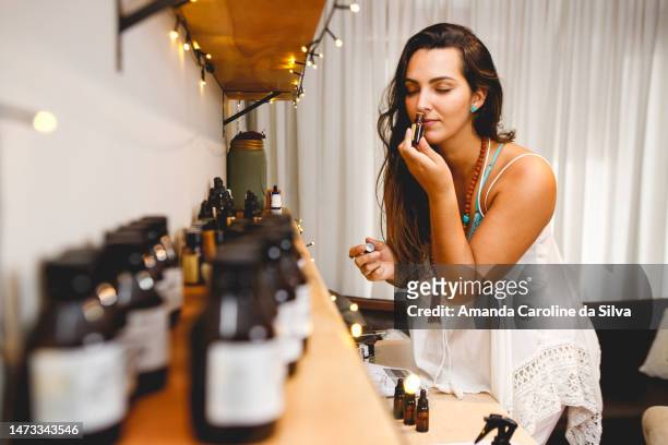 parfumeuse brésilienne travaillant dans son atelier, sentant les huiles essentielles - parfumeur créateur photos et images de collection