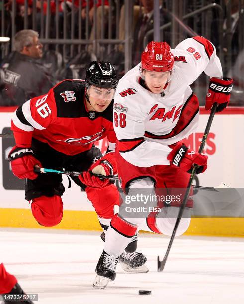 Martin Necas of the Carolina Hurricanes takes the puck as Timo Meier of the New Jersey Devils defends during the first period at Prudential Center on...