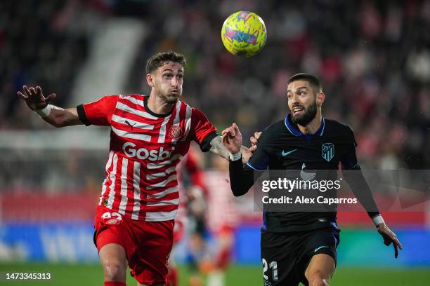 Santiago Bueno of Girona FC and Yannick Ferreira Carrasco of Atletico Madrid battle for a header during the LaLiga Santander match between Girona FC...