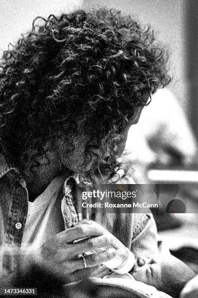 Saxophonist Kenny G gives a bottle to his newborn son at the brunch to celebrate the birthday of award-winning actress Nicollette Sheridan at the Bel...