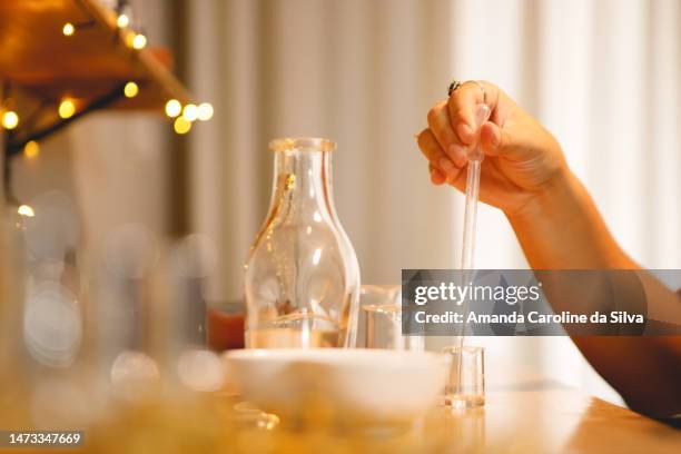 brazilian woman making natural perfumes in her workshop - perfume counter stock pictures, royalty-free photos & images