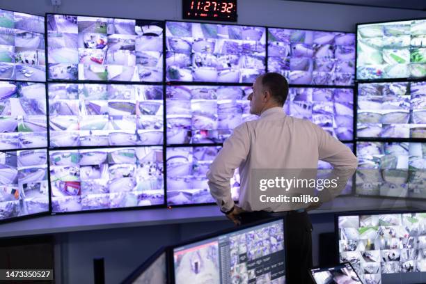 man working in surveillance room and looking at camera - surveillance monitor stock pictures, royalty-free photos & images
