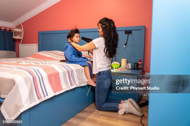 mother dries hair with a blow-dryer daughter - drying stock pictures, royalty-free photos & images