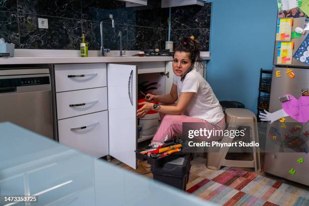 woman at home calling a plumber - diy disaster stock pictures, royalty-free photos & images