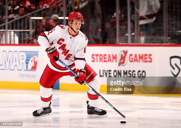 Jesperi Kotkaniemi of the Carolina Hurricanes looks to pass against the New Jersey Devils during the third period at Prudential Center on March 12,...